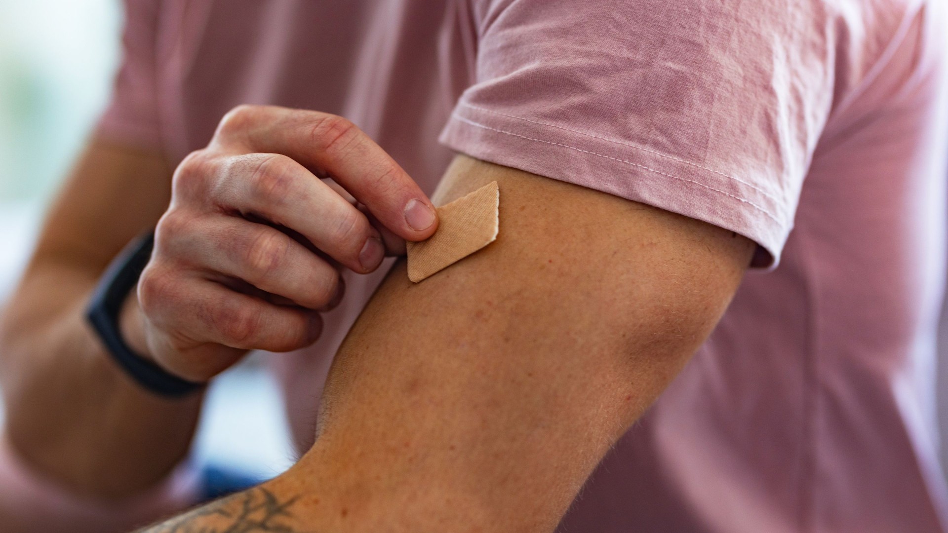 Persona che applica un cerotto alla nicotina sul braccio