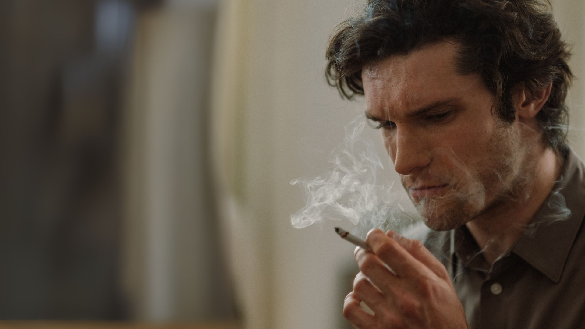 Uomo che fuma una sigaretta con sguardo pensieroso